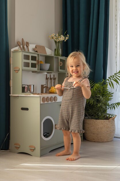 young child plays happily bright indoor kitchen setting with wooden toy appliances 1204629 3474